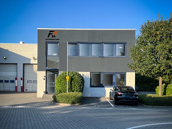 Modernes Gebäude mit Parkplatz und Pflanzen